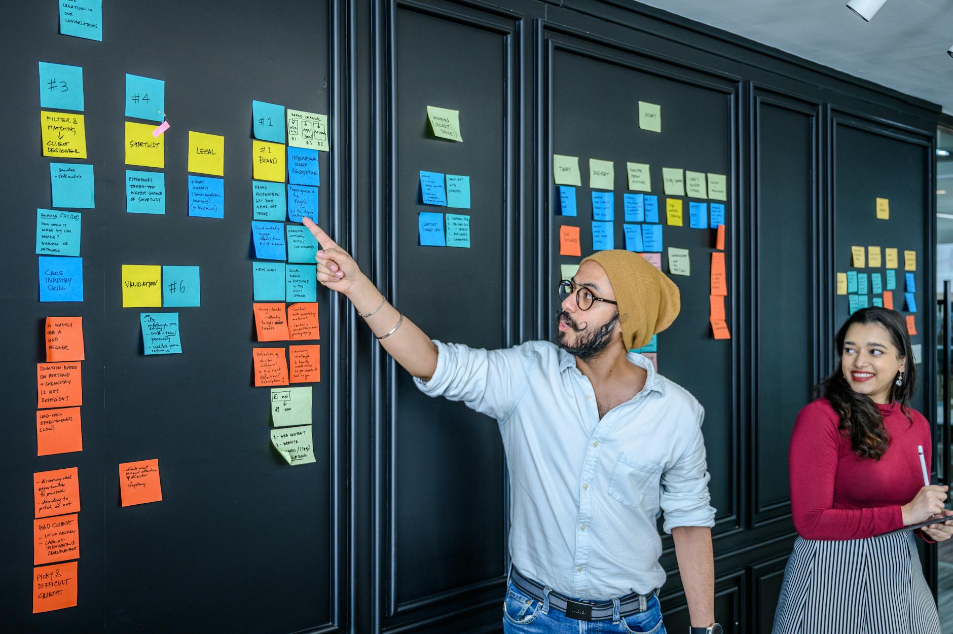 Team discussing project strategies with colourful sticky notes on a board.