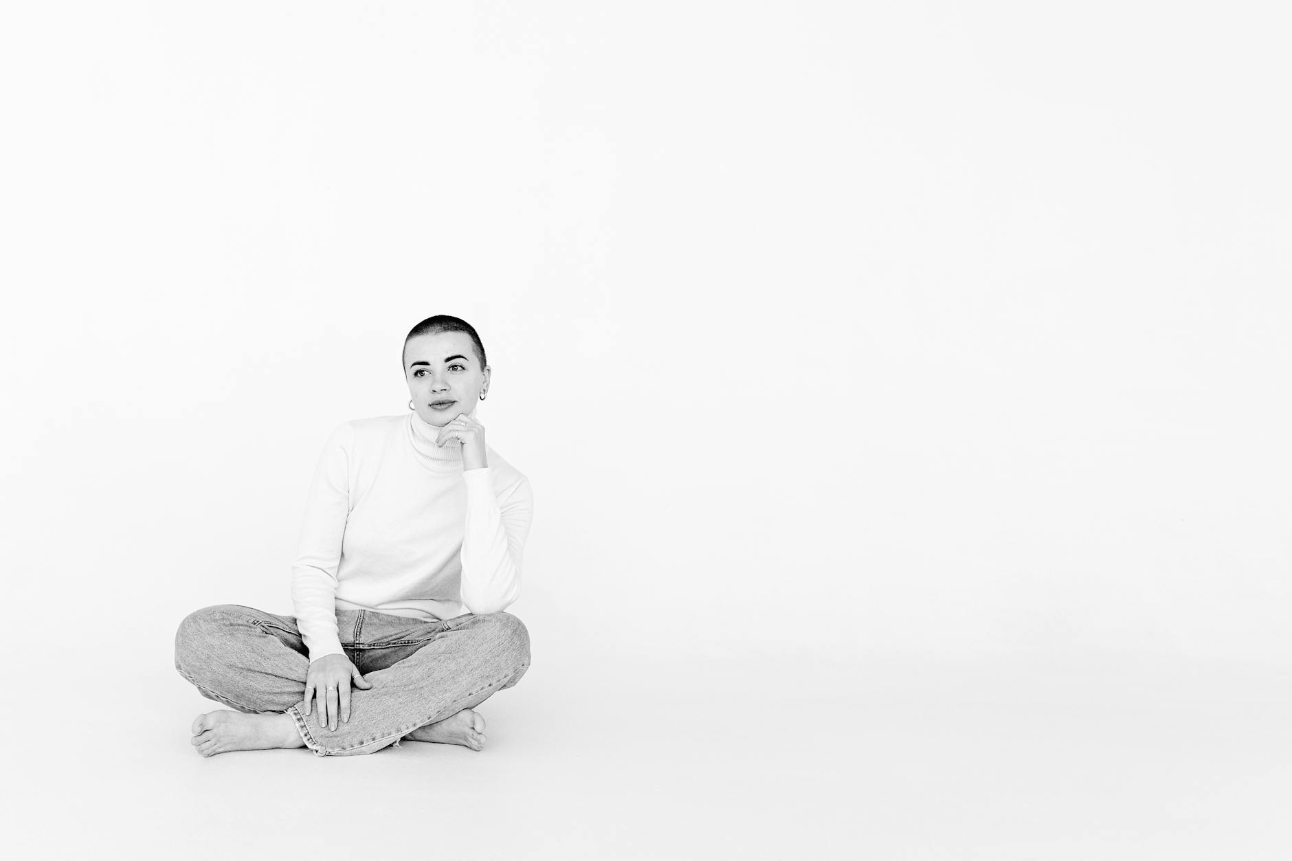 The founder as brand — minimalist studio portrait Elegant minimalist black and white photo of a woman sitting in a studio.