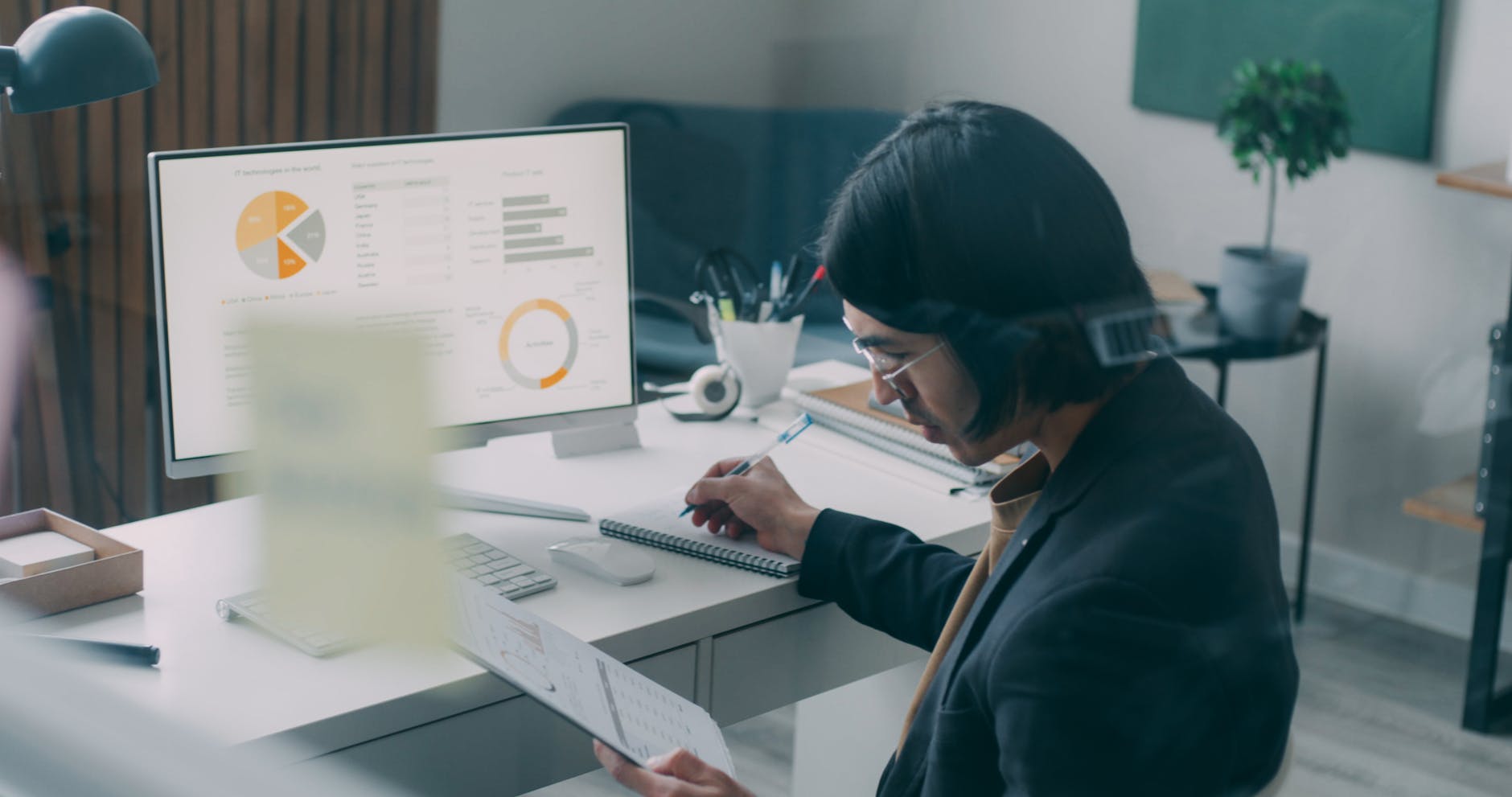 A professional reviewing analytics and charts at a modern office desk — the kind of close review a project-level AI ethics framework forces at brief acceptance.