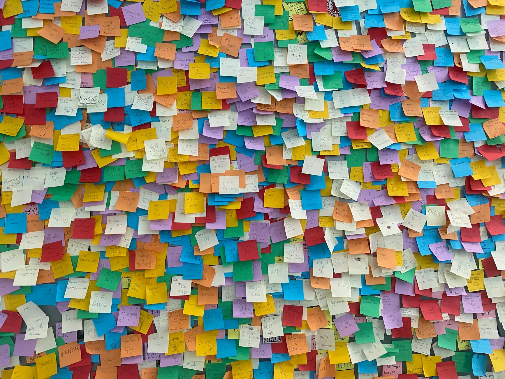 Bright and colourful sticky notes plastered on a wall, symbolising creativity and brainstorming.