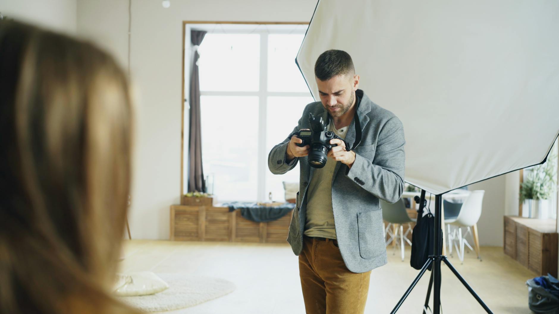 A photographer at work in a studio under controlled lighting — the operational reality of producing a consistent photographic style as a brand system layer.