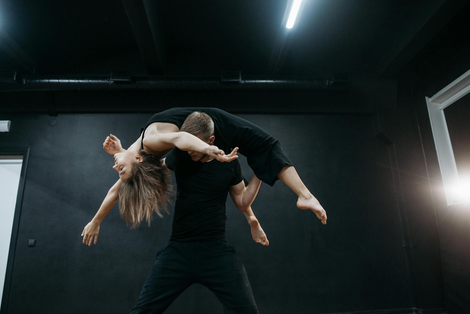 A dancer in mid-movement during a studio session — deliberate motion under constraint as metaphor for brand motion principles.