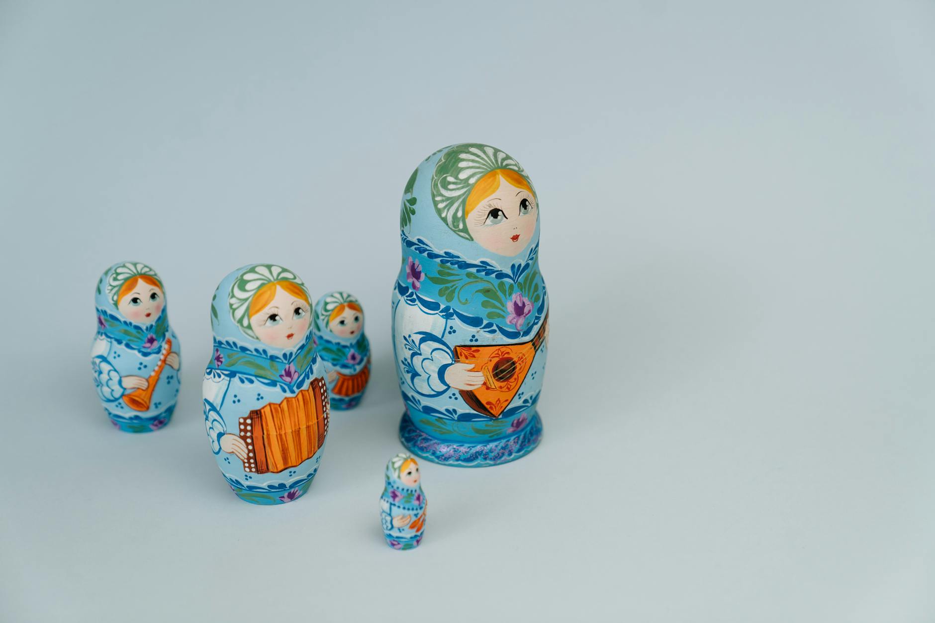 Russian nesting dolls in a line on a wooden surface — a familiar metaphor for the architectural decision between a parent brand and a separated child.