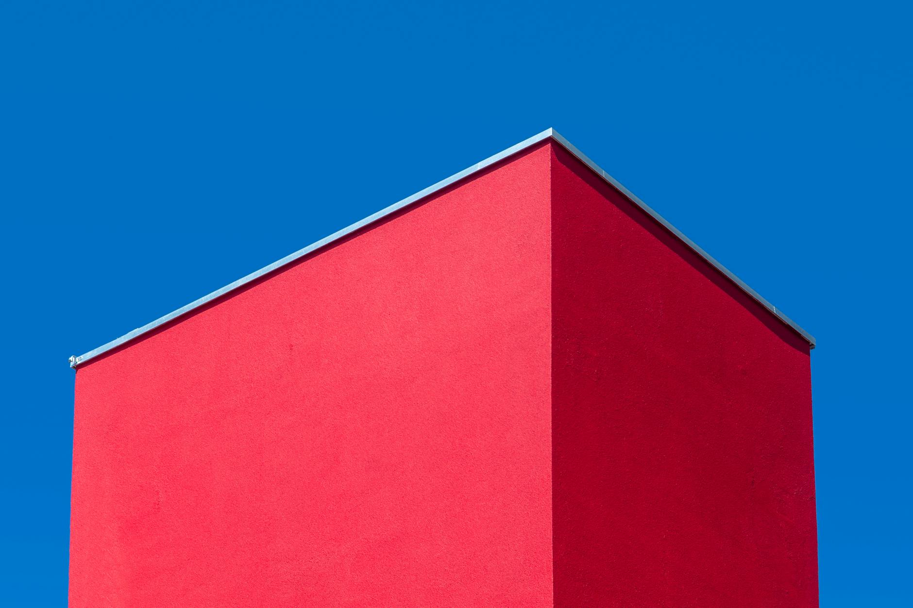 Saturated coloured walls in a geometric architectural composition — distinctive colour holding its character under constraint.