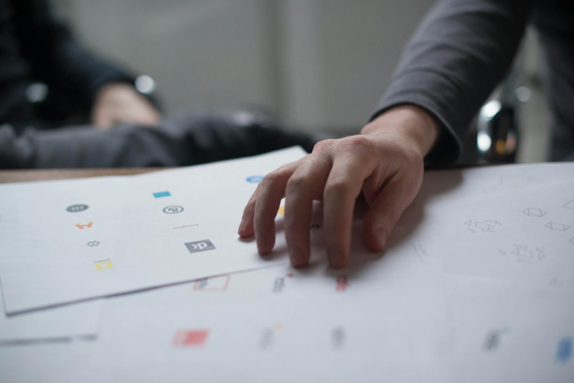 Design system vs brand book — featured image A designer reviewing brand guidelines in a studio — the artefact that governs identity across every channel.