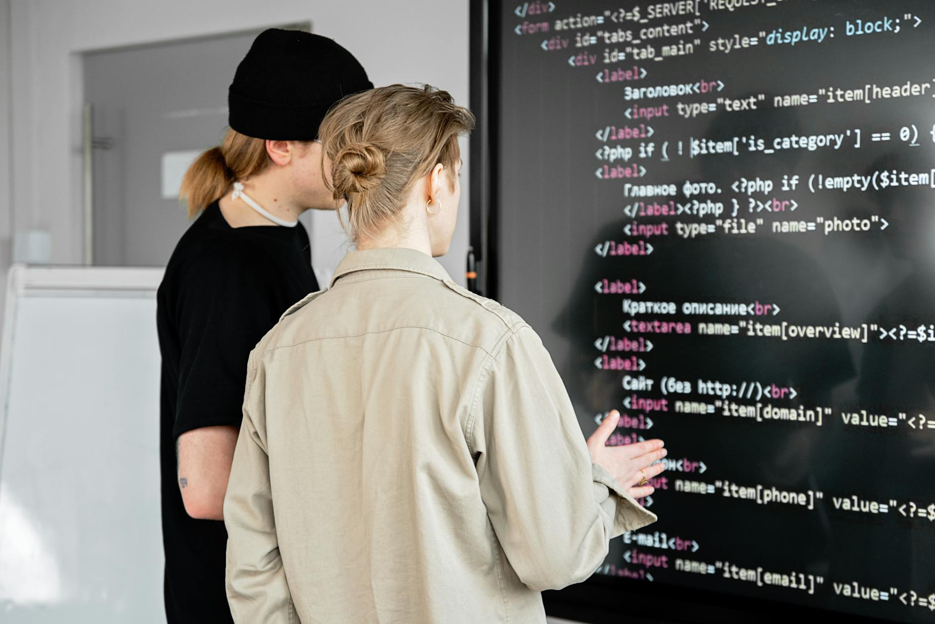 A developer and designer collaborating at a screen — the handover where brand decisions become code values.