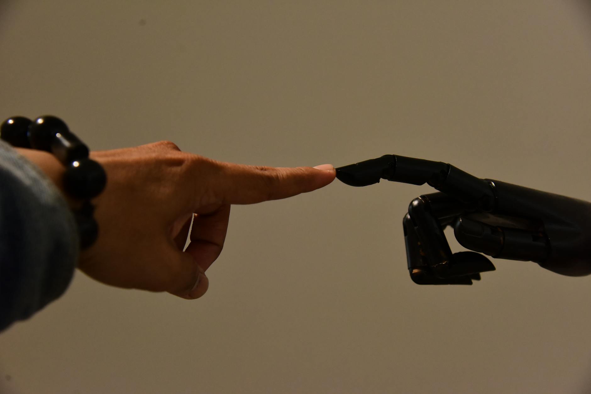 AI-generated assets and the brand system — featured image A robot hand and a human hand collaborating on a creative output — the line between governed and human-made.