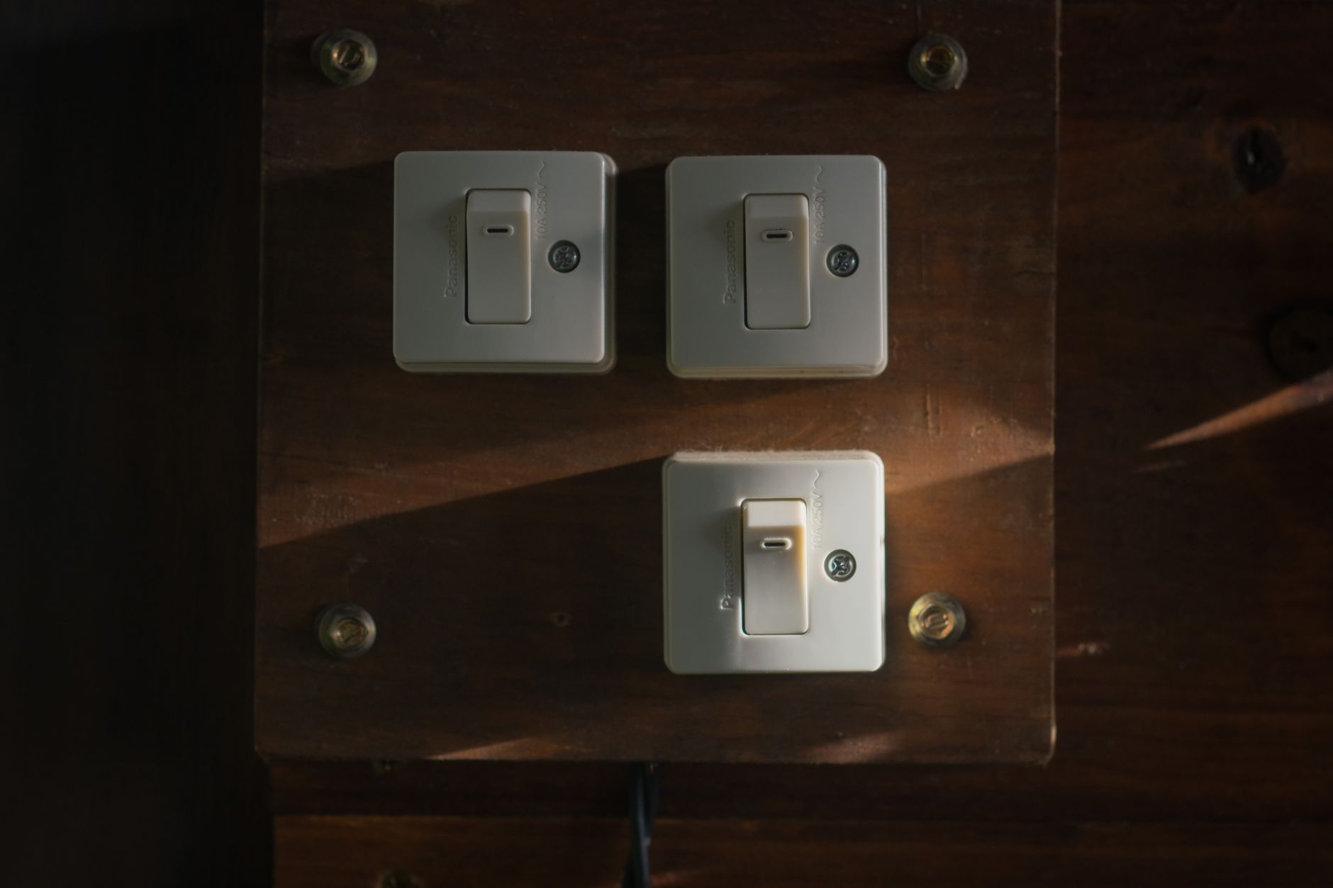 Brand dark mode strategy Light switches glowing in a dark interior, a metaphor for a brand dark mode strategy.