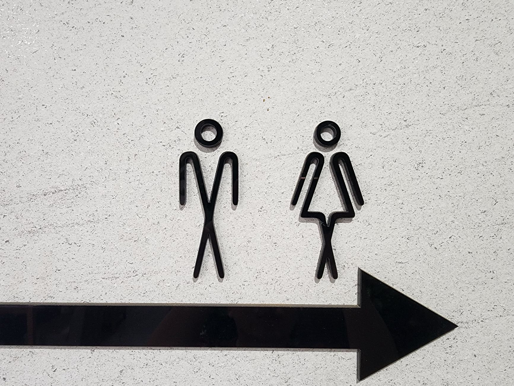 Minimalist pictogram signage on a wall, illustrating a brand iconography system.