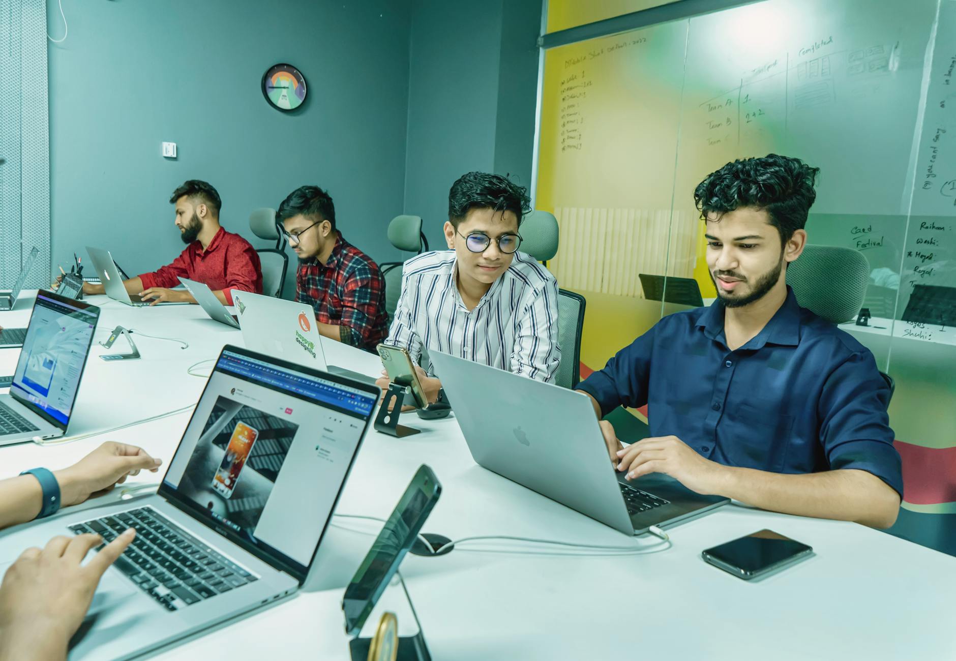 Young professionals working together in a modern office, using laptops.
