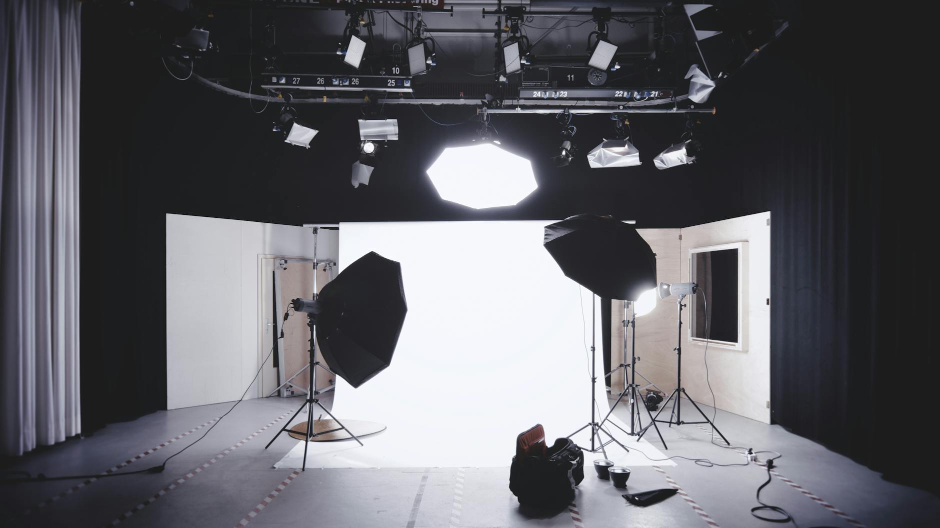The carbon cost of brand decisions A photography studio with lights, softboxes, and a white backdrop set up for a shoot.