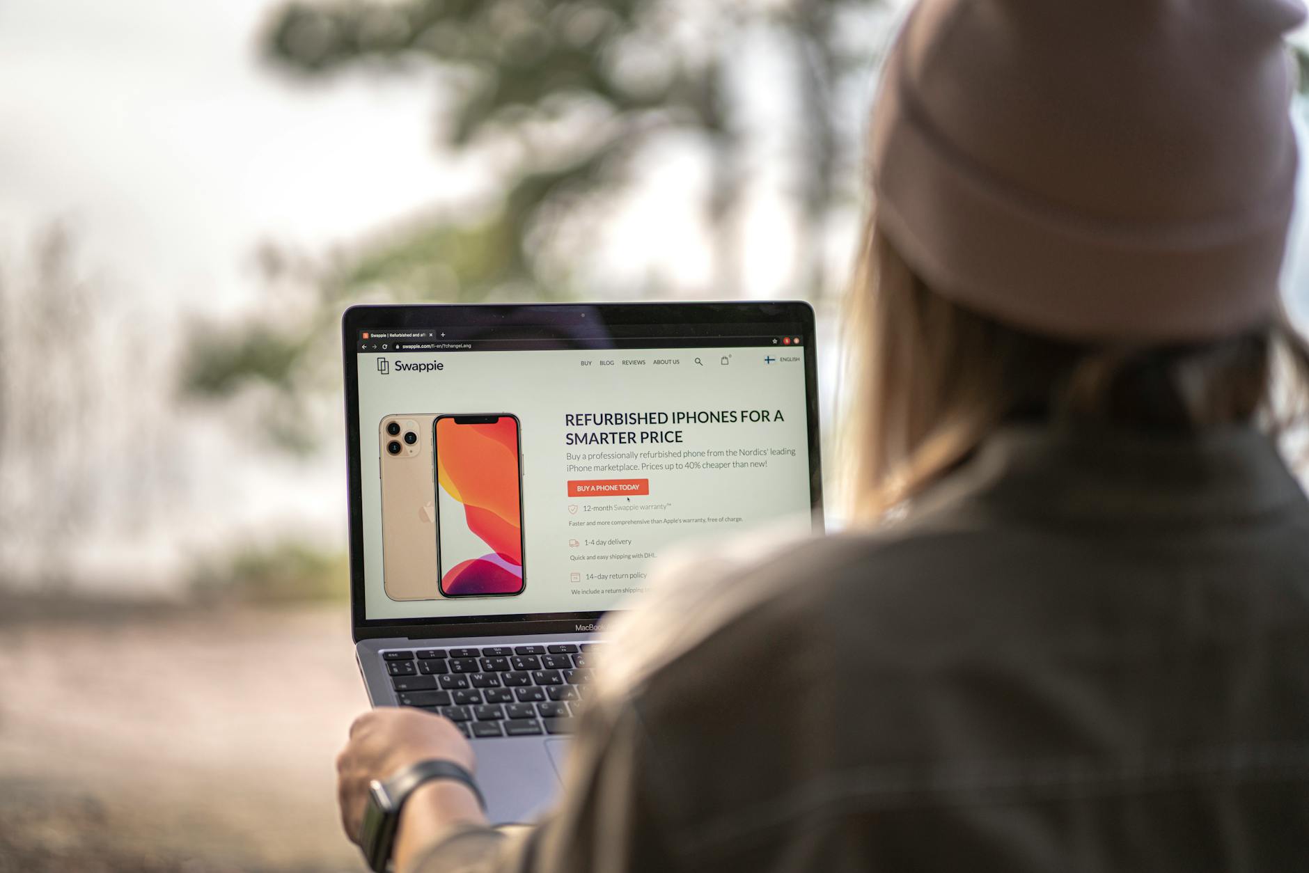 Pricing pages as brand artefacts A person using a laptop outdoors, comparing options on a pricing page.